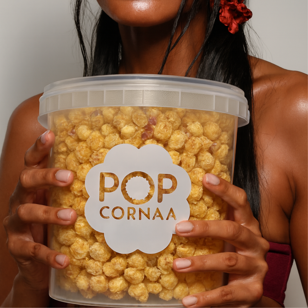 Person holding a container of popcorn with 'POP CORNAA' label