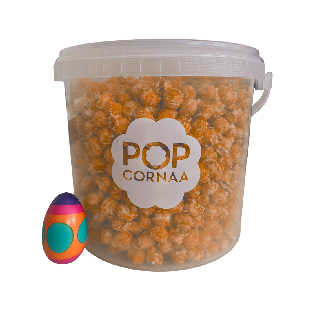 Bucket of 100%clean, dairy free Sriracha Soul popcorn with 'POPCORNAA' label and a colorful egg-shaped object on a white background