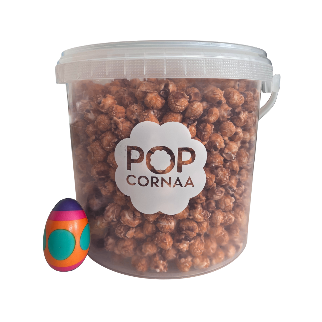 Bucket of 100% clean, dairy free gingerbread popcorn with 'POPCORNAA' label and a colorful egg-shaped object on a white background