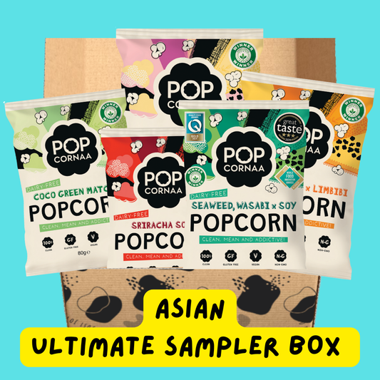 Assorted PopCornaa popcorn packages with visible branding on a blue background, labeled 'Asian Ultimate Sampler Box'.